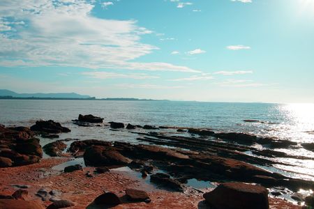 The blue sea of the stony coast which have grown with jungle of peninsula Santubong. Borneo.の写真素材