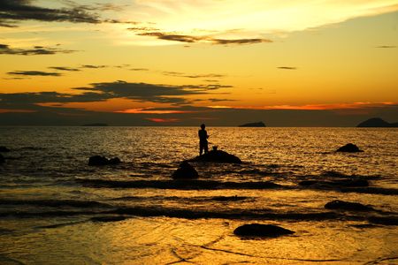 Sea sunset at stony sea coast of peninsula Santubong. Borneo.の写真素材
