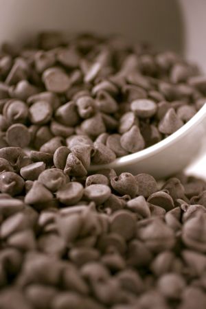 Chocolate chips overflowing from a large coffee mugの写真素材