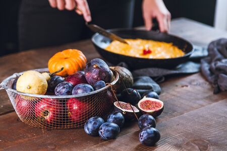 autumn fruits in a metal basket: plums, apples, pumpkins, figsの写真素材