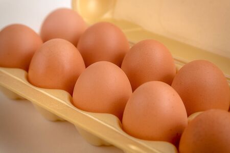brown large chicken eggs in yellow packaging close-upの写真素材