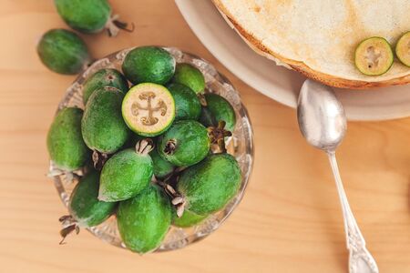 crystal plate with feijoa close-up, vintage silver spoon and thin pancakesの写真素材