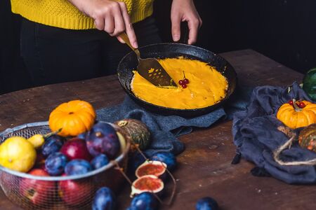 Autumn still life: orange and green pumpkins, walnuts, viburnum and pumpkin pie on a clothの写真素材