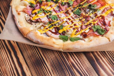 pizza with pepperoni, bacon, boiled pork, mustard and barbecue sauces, seasonings and herbsの写真素材