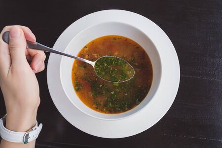 soup - fish soup with chopped herbs, spoon in handの写真素材