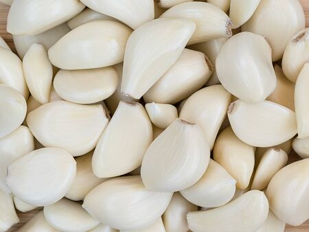 many peeled white cloves of garlic - food backgroundの写真素材