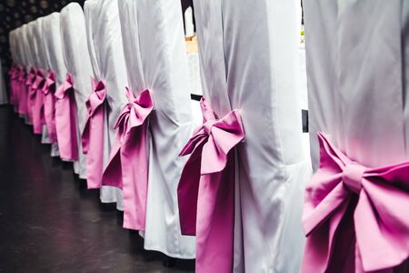 wedding banquet details chairs with pink bowsの写真素材