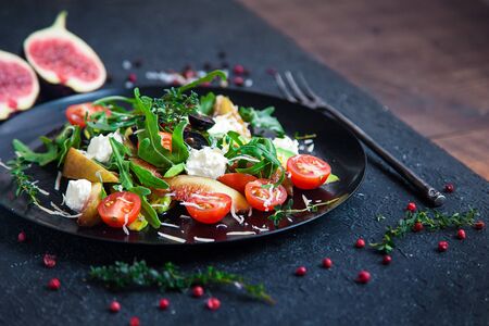 salad on a plate: arugula, cherry tomatoes, white figs, grated cheese, black grapes, avocadoの写真素材