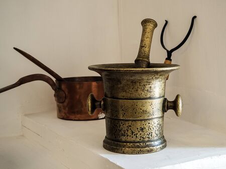 old metal large mortar and kitchen tools close-upの写真素材