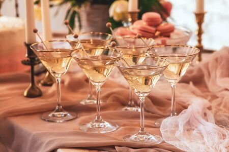 crystal martini glasses and sugar crystals on a festive table in beige colorsの写真素材
