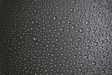 abstract background: many drops of water on a dark surface - non-stick coating in a pan. Black and white photoの写真素材