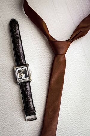 Wristwatches and brown tie of the groom close upの写真素材