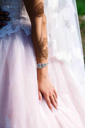 bride's hand on a pink wedding dress close-up, light and shadowの写真素材