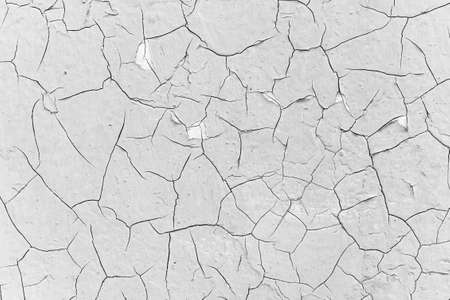 a lot of large cracks in the paint - black and white texture of the surface of an old metal plateの写真素材