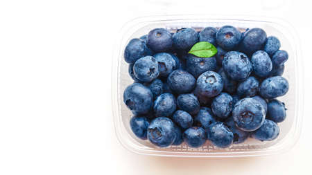 plastic container with blueberries on a white background. Place for your text. Top view, flatlayの写真素材