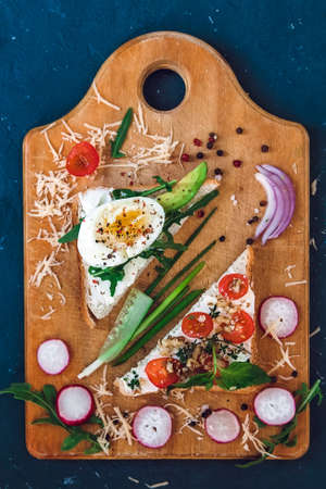 two sandwiches with curd cheese on a wooden cutting board, top viewの写真素材