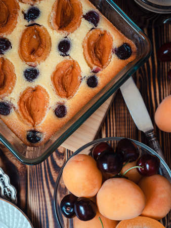 cottage cheese casserole with apricots and cherries in a rectangular glass shape close-up - homemade cakes, seasonal berries and fruits in a transparent bowlの写真素材