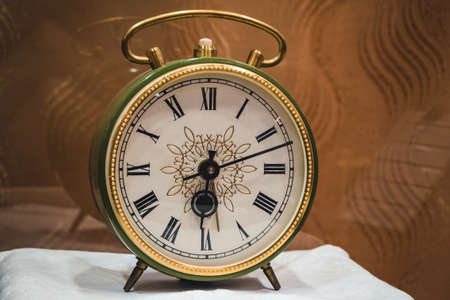 old green and golden color alarm clock with roman numerals in the museumの写真素材