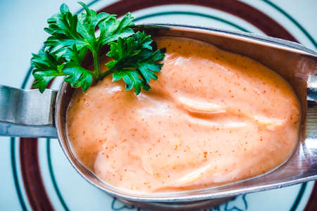 Pink shrimp sauce with parsley in a metal saucepan close-upの写真素材