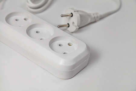 extension cord for three sockets with a long coiled cord on a white backgroundの写真素材