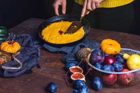 Autumn still life: orange and green pumpkins, walnuts, viburnum and pumpkin pie on a clothの写真素材