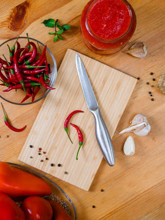cooking adjika - a traditional hot Georgian and Abkhaz sauce. Chili pepper, spices, garlic - ingredients on a wooden table, flatlayの写真素材