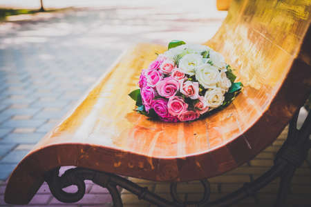 wedding bouquet of multicolored roses on a benchの写真素材