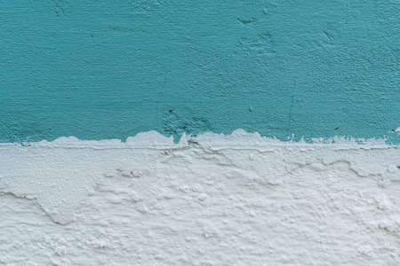 old concrete wall painted in two colors - blue top, white bottomの写真素材