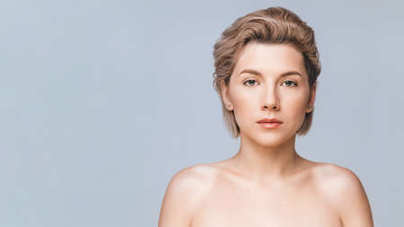 Image with beautiful blonde girl on gray background. Beauty & Skin care concept. Copy spaceの写真素材