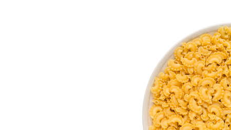 many dry unprepared pasta - cockerels on a round beige plate. Isolated on a white, copy space for textの写真素材