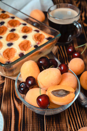 fresh summer seasonal berries: apricot and cherry - ingredients for a pie on a wooden backgroundの写真素材