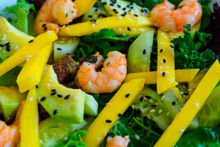 diet salad with shrimp, mango, avocado, cucumber, black sesame seeds and lettuceの写真素材