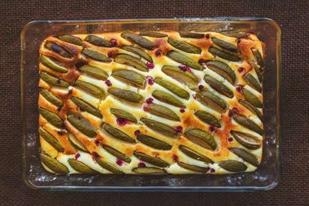 rectangular cheesecake with feijoa and raspberries in a glass form, top view