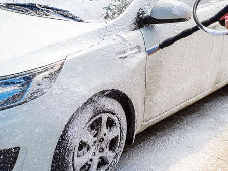 white car at the self-service car wash in foamの写真素材