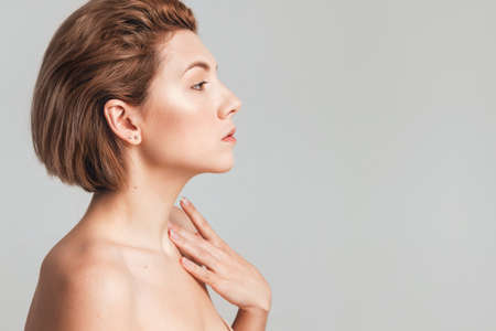 young beautiful blonde side view in a studio on a light background. No retouching. The concept of natural beauty. Copy space for textの写真素材