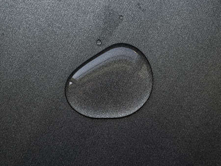 large drop of water on gray metal surface - abstract backgroundの写真素材