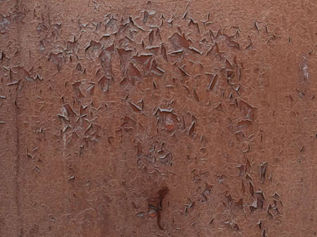 cracks and flakes of old brown paint on a metal surface - textureの写真素材