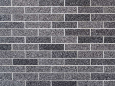 wall decorated with bricks of different shades of gray close-upの写真素材