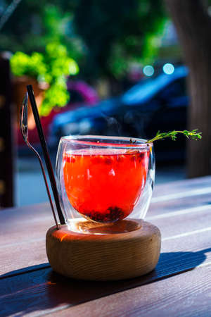 Siberian tea with linden and pine cones on a wooden table on the terraceの写真素材