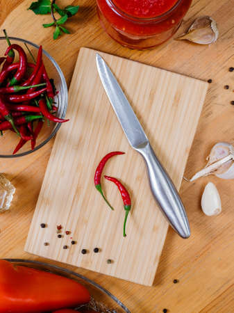 chili peppers on a cutting board on a wooden table, cooking hot sauce. View from aboveの写真素材