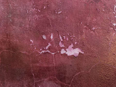 peeling burgundy paint on a concrete wall - cracked textureの写真素材