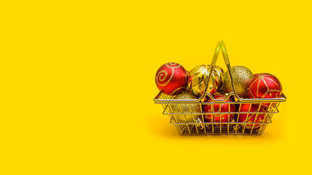 horizontal festive yellow background with copy space: toys on the Christmas tree in a metal shopping basketの写真素材