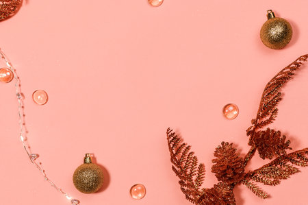 Christmas background: shiny golden balls, beads, cones and branches on a pink background - flat lay. Copy space centerの写真素材