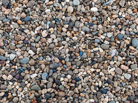 nature background: many small stones of different colors - pebbles on the beachの写真素材