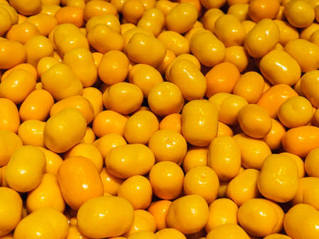 Dragee Marshmallows with orange zest in white chocolate close-upの写真素材