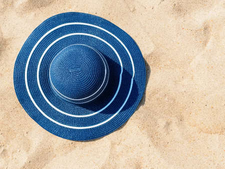 large blue straw hat on the sand, copy space. Beach holiday conceptの写真素材