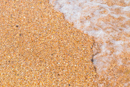 small wave on the sandy shore close-upの写真素材