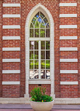 window on the wall in a gothic brick buildingの写真素材