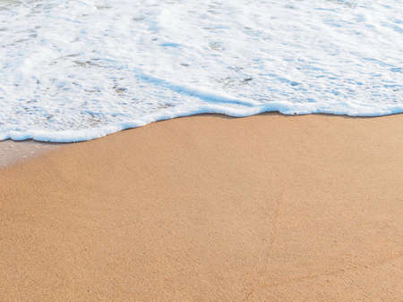 horizontal shot: sea foam wave on a sandy beach, copy spaceの写真素材