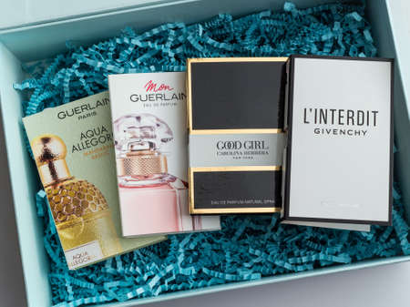 Moscow, Russia - August 14, 2021: Aroma box: Mon Guerlain, Aqua Allegoria Mandarine-Basilic, Carolina Herrera GOOD GIRL, Givenchy L'Interdit on blue paper shavingsのeditorial素材
